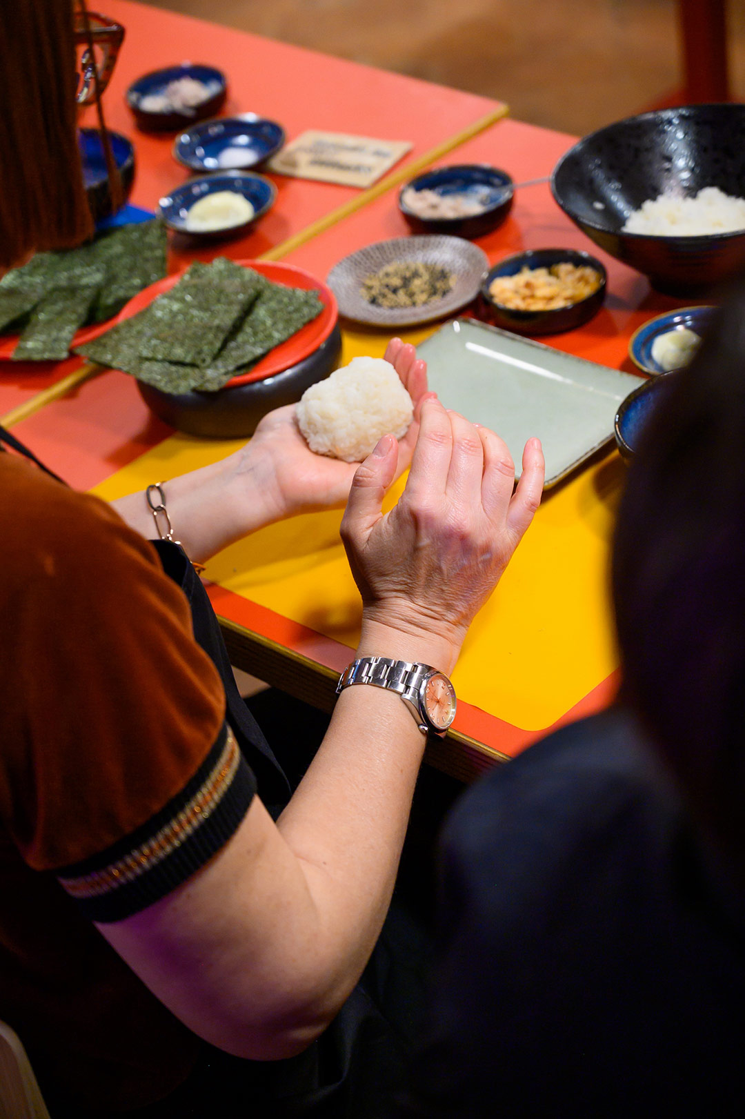 Mani al lavoro durante il corso di onigiri